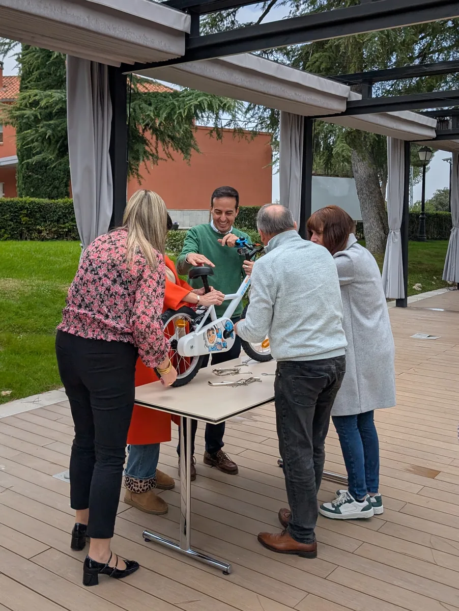 Equipo de empresa montando bicicletas infantiles en el team building solidario Bicis con Futuro