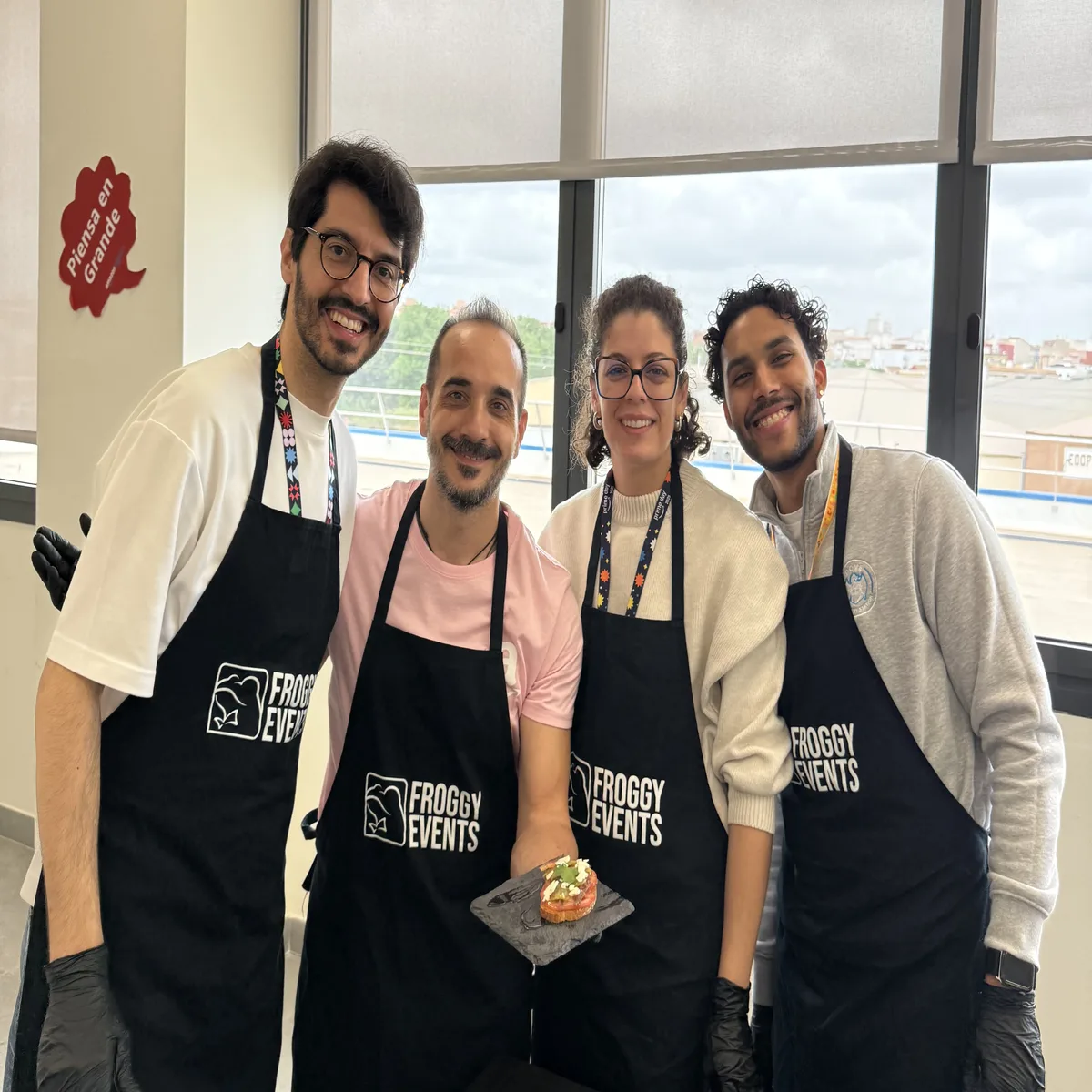 Equipo de empresa con delantales Froggy Events mostrando su tapa creativa en el taller de cocina Master Cooking