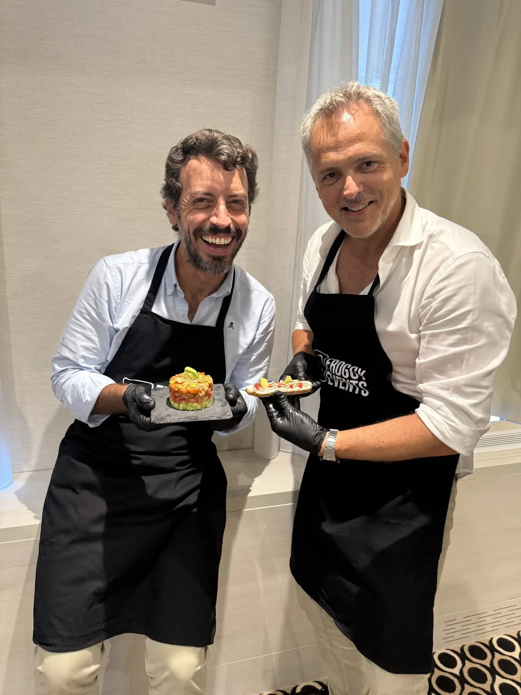 Participantes en el taller de cocina para empresas Master Cooking mostrando sus platos con delantales Froggy Events