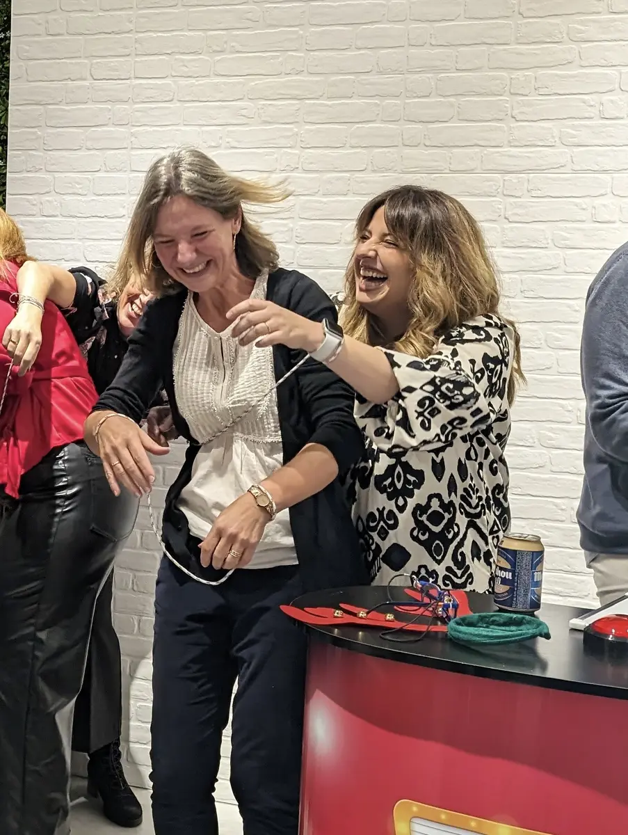 Participantes riendo durante una prueba de un concurso de televisión para empresas estilo trivial corporativo