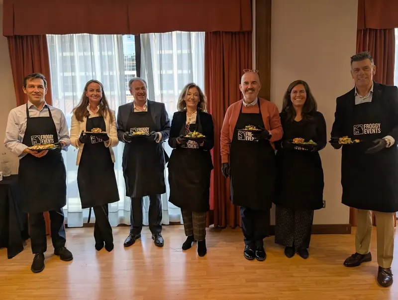 Grupo de empresa con delantales presentando sus platos en un Master Cooking