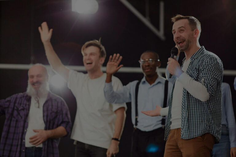 Participantes levantando la mano y riendo con micrófonos en actividad de concurso de TV Megaconcurso para empresas