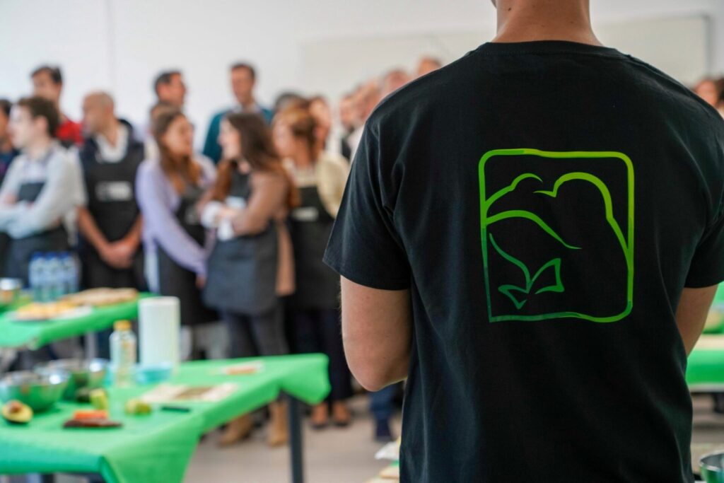 Monitor de Froggy Events con camiseta corporativa supervisando un taller de cocina Mastersushi para empresas